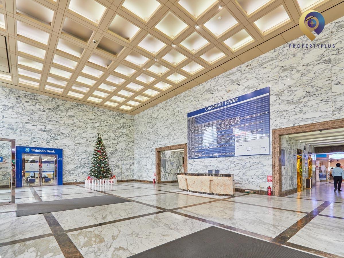 Lobby area of Charmvit Tower with marble walls and reception desk